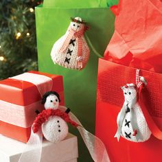 two small snowmen sitting next to wrapped presents