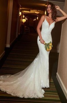 a woman in a wedding dress standing next to a wall