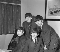 the beatles posing for a photo in their office