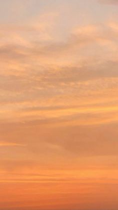 an airplane is flying in the sky at sunset