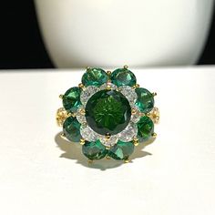 15K 610 Solid Yellow Gold Emerald, White Topaz Flower Cluster Ring ...Marked 610 means 61% of Gold...Total of weights 6.2grams...Size 8.25...Measure of Face 19.5MM....It's in very good condition. Green Flower-shaped Jewelry For Anniversary, Green Flower-shaped Anniversary Jewelry, Green Flower Shaped Anniversary Jewelry, Fine Jewelry Round Flower Ring With May Birthstone, Fine Jewelry May Birthstone Flower Ring, Green Cubic Zirconia Flower-shaped Jewelry, Green Gemstone Flower Ring, Luxury Green Flower-shaped Jewelry, Green Cluster Ring