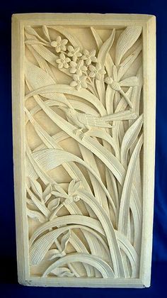 an intricately carved wooden panel with flowers and leaves on it's sides, against a blue background