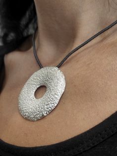 "This big open round pendant is a stunning and unique handmade piece of jewelry made of sterling silver and features a beautiful texture! Τhe pendant is passed on a grey silk cord, with a handcrafted hook clasp. The pendant is designed in the shape of a curved wide circle, adding a modern and statement-worthy touch to any outfit, which makes you look twice DESCRIPTIONS and MEASUREMENTS: Materials: Sterling silver. Diameter:approx 4,5(cm) 1,77(in)\". Length cord: 42,0 (cm) 16,53 (in)\". ΑLSO COMBINED WITH : www.etsy.com/shop/ArtisJewels?ref=seller-platform-mcnav&search_query=S13 SEE MORE NECKLACES HERE: www.etsy.com/shop/ArtisJewels?ref=seller-platform-mcnav§ion_id=35815722 Visit my Etsy shop, ArtisJewels, to see more necklaces and jewelry and other unique handmade pieces. www.etsy.com/shop Luxury Silver Open Circle Jewelry, Handmade Silver Circle Necklaces, Handmade Silver Circle Necklace, Handmade Circular Silver Necklace, Unique Silver Circular Necklace, Full Moon Necklace, Silver Pendent, March Birthstone Necklace, Hammered Jewelry