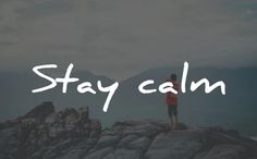 a person standing on top of a mountain with the words stay calm written in white