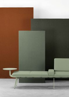 a couch and table sitting next to each other in front of some colored wall panels