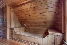 an empty room with wooden walls and drawers