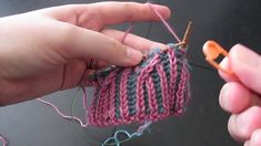 someone is knitting something with scissors in their hand and another person is holding the yarn