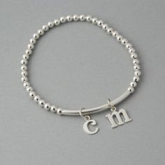 This is my new go to bracelet. Made for easy wear with high quality stretchy cord. Sterling silver beaded bracelet with a sterling bar. Silver initials dangle perfectly. Wear it alone or layered up! So cute. Listing is for one bracelet. **Please leave initial choices in notes at checkout** Comes in a Organza bag, gift box available or additional $2 PLEASE NOTE WHEN ORDERING, MEASURE YOUR WRIST, THEN ADD 1/2 INCH FOR A COMFORTABLE FIT. bracelet is adjustable by 1/2 inch. x-small 5-6 inches small Silver Minimalist Stretch Bracelet As Gift, Classic Adjustable Sterling Silver Stretch Bracelet, Personalized Silver Beaded Bracelets For Everyday, Silver Stackable Charm Bracelet For Everyday, Silver Bracelets With Initials For Everyday, Everyday Silver Bracelets With Initials, Adjustable Sterling Silver Charm Bracelet With Round Beads, Sterling Silver Charm Bracelet With Round Beads For Everyday, Sterling Silver Adjustable Charm Bracelet