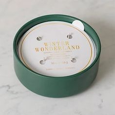 a white and green container sitting on top of a marble counter next to a clock