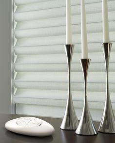 three silver candlesticks sitting next to each other on a table