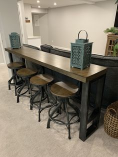 a bar with four stools in front of it and a basket on the floor