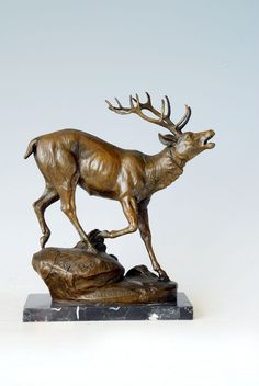 a bronze statue of a deer on a rock