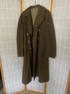 1950’s army green wool coat with eagle buttons. Has a repaired hole, rips on the inner neck, and a small pink stain. Being sold as isShoulders: 19”Shoulder to hem: 49” Military Wool Double-breasted Pea Coat, Military Style Wool Pea Coat With Button Closure, Winter Military Outerwear With Button Closure, Military Style Wool Outerwear In Khaki, Vintage Pea Coat With Button Closure, Historical Long Coat For Fall, Historical Fall Outerwear With Buttons, Winter Military Outerwear With Buttons, Green Uniform Style Outerwear For Fall