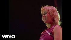 a woman with pink hair standing in front of a microphone