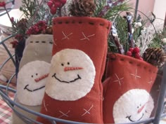 three christmas stockings with snowmen on them in a basket