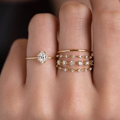 a woman's hand with three different rings on her fingers and one has a diamond ring