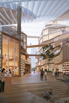 people are walking around the inside of a large building with many bookshelves and stairs