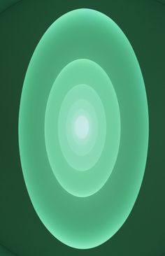 a circular light in the middle of a dark room with green walls and ceiling lights