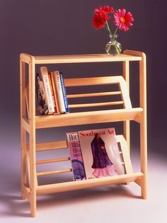 a wooden shelf holding magazines and a vase with flowers