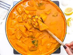 a person is stirring some food in a pot with a wooden spoon on the stove