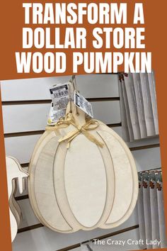 a wooden pumpkin hanging from the side of a wall with text overlay that reads transform a dollar store wood pumpkin