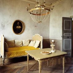 a living room filled with furniture and a chandelier hanging over it's head