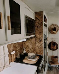 a small kitchen with white cabinets and wood wallpaper on the backsplashes