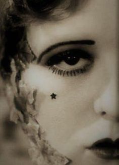 a black and white photo of a woman's face with stars on her forehead