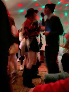 a group of people dancing in a room with lights on the walls and flooring