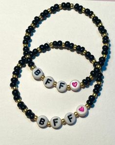 This listing is for a set of 2 BFF bracelets. Each bracelet is made on stretchy cord and has black and gold seed beads, BFF letter beads and a heart bead. The color of the heart beads may be different than pictured but both bracelets will have matching hearts.  If unsure of sizing, please include ages in the personalization box and I can adjust accordingly.  Bracelets will each come in a small organza bag ready to be gifted :) Cheap Black Friendship Bracelets With Letter Beads, Casual Black Friendship Bracelets With Letter Beads, Friendship Black Jewelry With Letter Beads, Black Heart Beads Bracelet For Friendship, Black Friendship Bracelets With Letter Beads, 2 Bff, Snowflake Party, Bff Bracelets, Rubber Band Bracelet