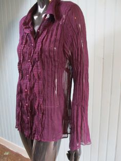 Vintage ruffled shirt in deep purple.  This is in scrunch fabric with sheer flared  sleeves,  the front has tiny pearl buttons to close and is ruffled.  It has a small collar and is slightly fitted. Dimensions: Length: 27 Inches. Sleeve: 25 Inches. Chest: 40 Inches. Made by DPM. Long Sleeve Blouse With Crinkle Texture For Summer, Summer Long Sleeve Crinkle Texture Blouse, Summer Long Sleeve Blouse With Crinkle Texture, Purple Blouse With Ruffled Collar, Long Sleeve Blouse With Crinkle Texture For Fall, Purple Summer Party Shirt, Purple Party Shirt For Summer, Fitted Bohemian Ruffled Tops, Fitted Bohemian Ruffle Top