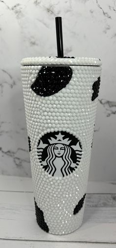 the starbucks cup is decorated with black and white beads