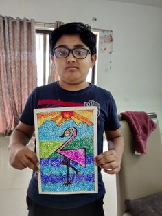 a young man holding up a colorful drawing