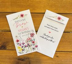 two greeting cards with flowers on them sitting next to each other in front of a wooden background