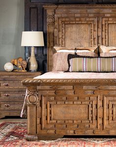 a large bed sitting next to two lamps on either side of it and a wooden headboard