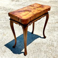 a small wooden table sitting on top of a cement ground