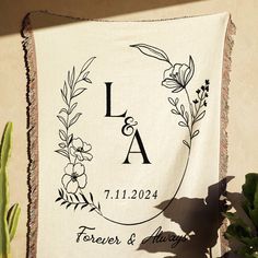 a personalized wedding banner hanging on a wall next to a potted cacti