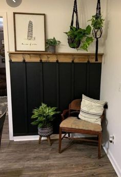 a room with a chair, potted plants and pictures on the wall above it