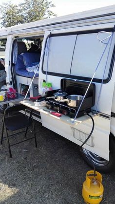 a camper van is parked with its door open and it's cooking on the stove