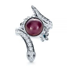 1139 Platinum Ring   96 Diamonds - 1.25 ctw   1 Blue Irradiated Diamond - .01 ctw   2 Black Diamonds .01   Clarity: VS2 - Color: F-G   Joseph Jewelry. This spectacular ladies’ fashion ring features a large cabochon cut ruby bezel set at the top of a platinum band in the shape of a snake, accented by channel and pave set white diamonds, milgrain, and other organic elements. It was created for a client as a custom piece, and it can provide wonderful inspiration as you work to develop your own cust Ruby Engagement Ring, Snake Ring, Jewelry Rings Diamond, A Snake, Fashion Ring, Platinum Ring, Ruby Ring, Top View, Flower Jewellery