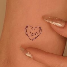 a woman's stomach with a small tattoo on the side of her body and an outline of a heart