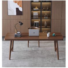 a desk with a laptop on it in front of a bookcase and bookshelf