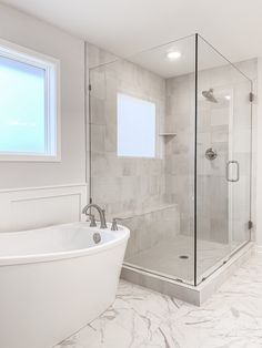 a white bath tub sitting next to a walk in shower