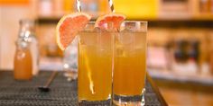 two glasses filled with drinks sitting on top of a table