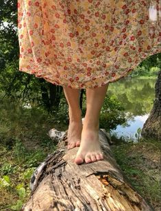 a woman standing on top of a tree log