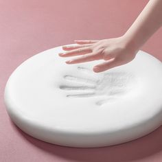 a person's hand is on top of a white object