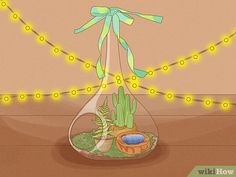 a glass vase with plants in it sitting on a table next to a string of lights