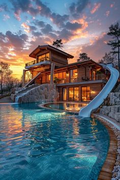 a house with a slide in the middle of it at sunset or sunrise, as seen from the pool