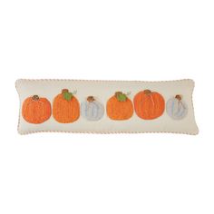 an embroidered pillow with three pumpkins on it