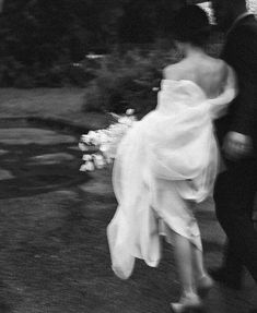 a bride and groom walking under an umbrella